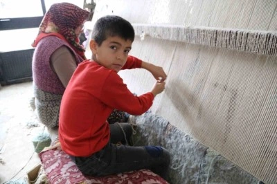 Tatillerde annesiyle halı dokuyor