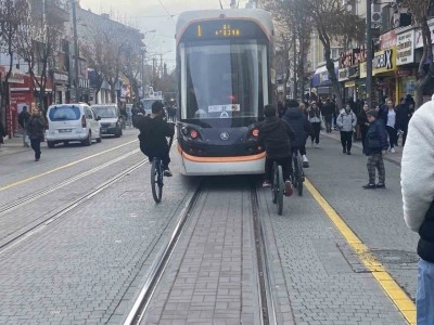 Tramvayın arkasına tutunan bisikletli çocuklar canlarını tehlikeye attı